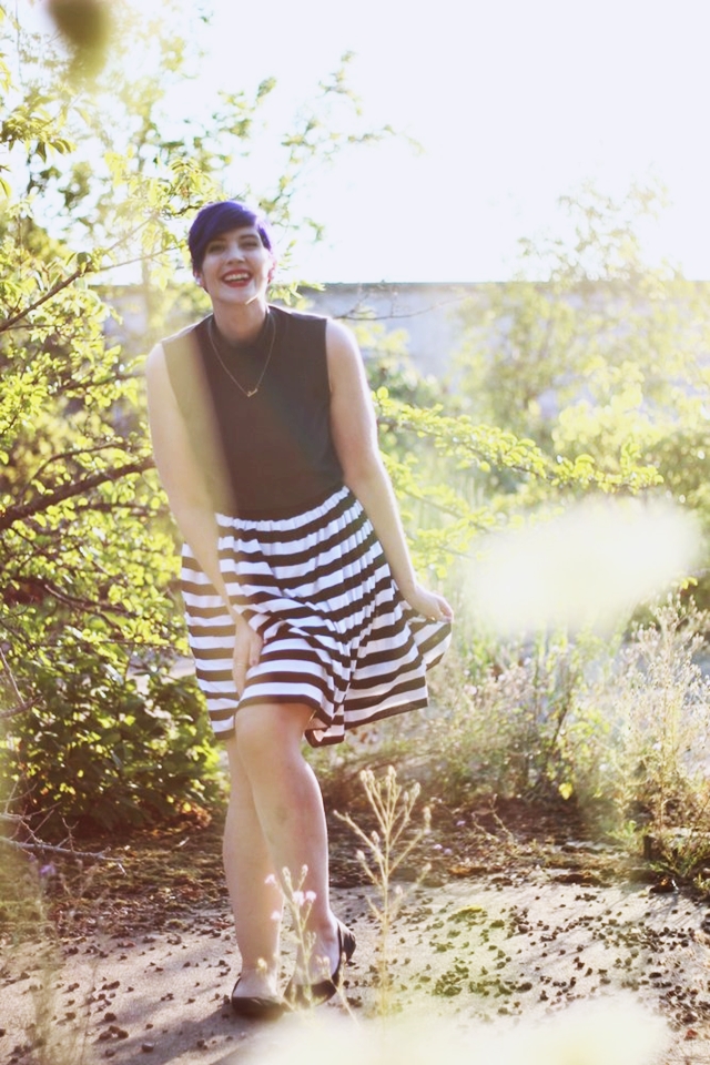 Outfit: Striped skirt, black sleeveless mock turtleneck, dainty gold necklace, black flats, purple pixie cut