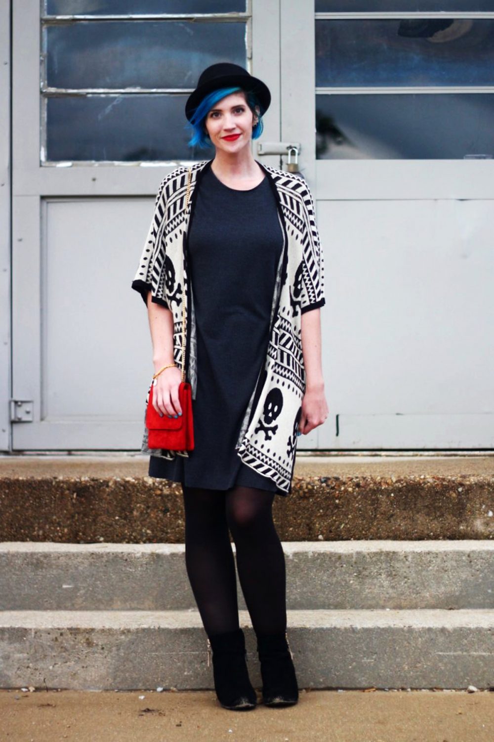 Outfit: Wearing a cardigan with a skull pattern, thrifted gray t-shirt dress, red purse, red lipstick, blue hair, black pork pie hat, black tights, black booties