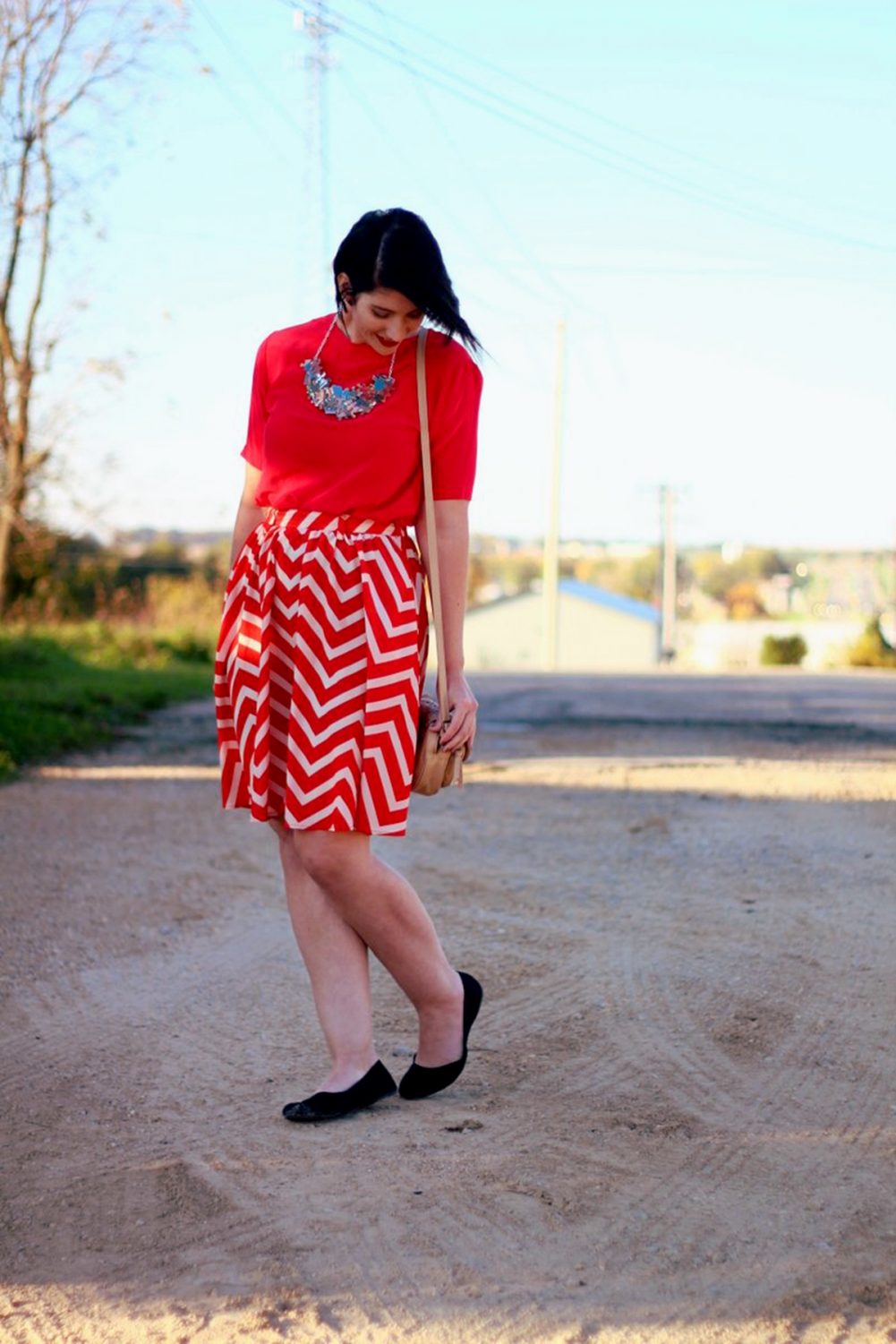 Outfit: Vintage red top, DIY puzzle piece necklace, red lipstick, thrifted orange chevron skirt, beige cross body purse, black flat shoes. 