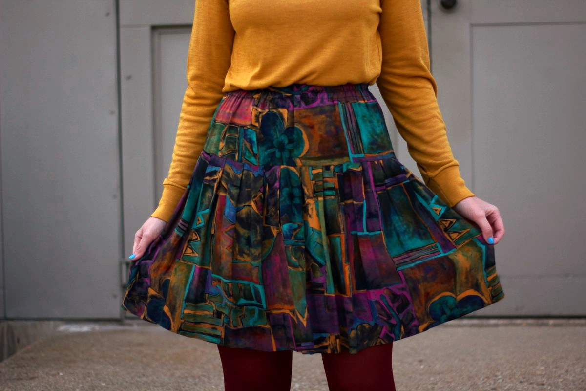 Outfit details: mustard yellow turtleneck, multi colored skirt, maroon tights