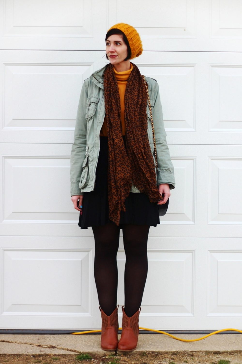 Back To Basics: Turtleneck Sweater & Utility Jacket | www.theoutfitrepeater.com Outfit: mustard yellow turtleneck, olive green utility jacket, leopard print scarf, yellow knit hat, black skater skirt, black tights, cognac colored boots, navy blue quilted purse