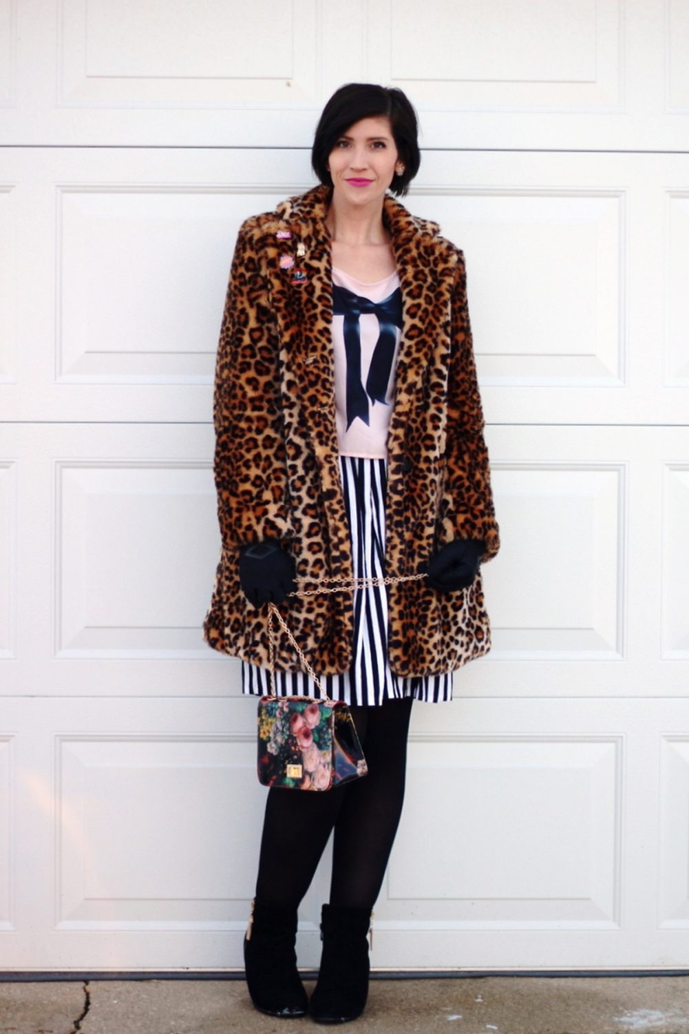 The Trick To Adding Flair To Outerwear | www.theoutfitrepeater.com Outfit: leopard print coat, cool enamel pins, graphic bow tee, black and white striped skirt, black tights, black booties, floral print purse